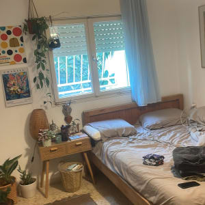 חלון זכוכית עם וילון כחול בחדר שינה