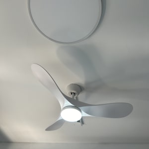 מאוורר תקרה עם תאורה מותקן על תקרה לבנה