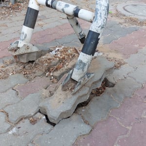 עמוד מתכת עם סימני שחיקה על מדרכה