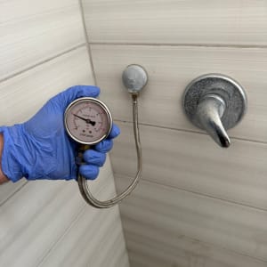 מד לחץ מים מחובר לברז בחדר אמבטיה