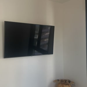 טלוויזיה מותקנת על קיר בחדר עם חלון גדול