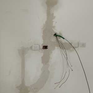 חוטי חשמל יוצאים מקיר עם שקעים