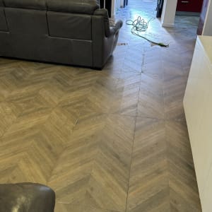 אדם מנקה רצפה עם צינור מים ודלי בחוץ