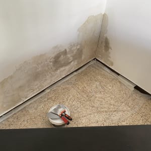 קיר עם רטיבות, דלי וכלי עבודה לתיקון