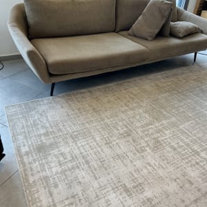 ספה חומה עם כריות על שטיח בהיר