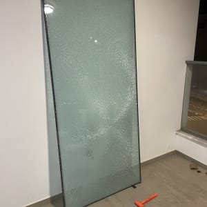 זכוכית שבורה עם פטיש כתום על הרצפה