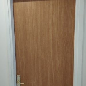 דלת עץ עם ידית מתכת במסגרת לבנה