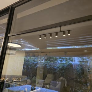 חלון אלומיניום עם תאורה פנימית וגינה ברקע