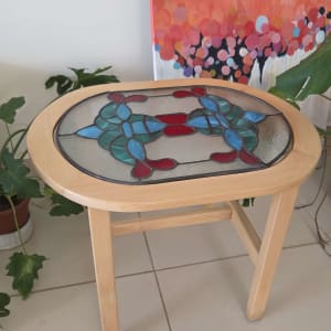 שולחן עץ עם זכוכית צבעונית על רקע ציור