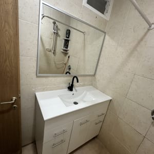 חדר אמבטיה עם כיור ומראה, מתאים לעבודת שיפוץ