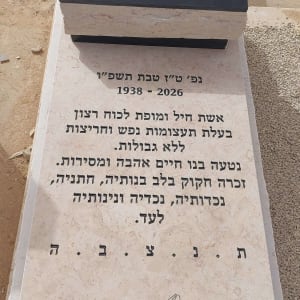 מצבה עם כיתוב בעברית ועיטור פרחים