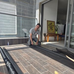 אדם עובד על מסגרת אלומיניום במרפסת