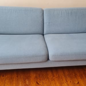 ספה כחולה על רצפת עץ