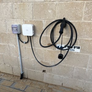 כבל טעינה לרכב חשמלי על קיר לבנים