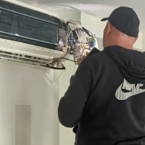 טכנאי בודק מזגן עם חוטים חשופים