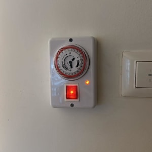 טיימר חשמלי עם מתג מואר על קיר