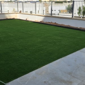 דשא סינתטי מותקן בחצר מגודרת