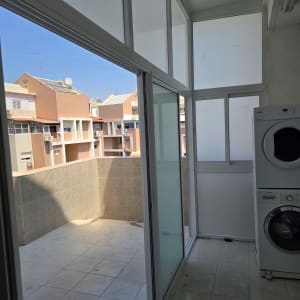 מרפסת סגורה עם חלונות אלומיניום ומכונת כביסה