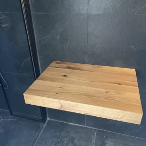 מדף עץ מותקן על קיר בחדר אמבטיה מודרני