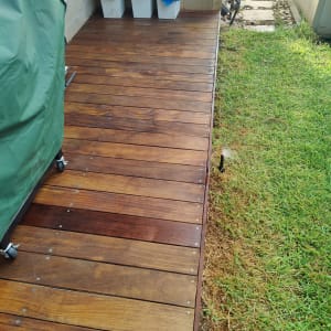 דק עץ ליד דשא ירוק עם פחי אשפה