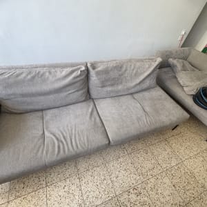 ספה אפורה עם צינור ניקוי על הרצפה