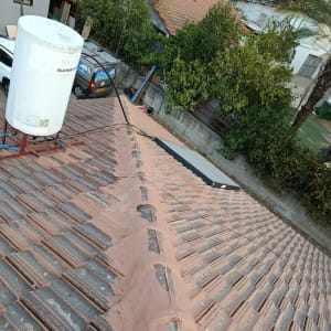 גג רעפים עם דוד שמש ומבנים ברקע