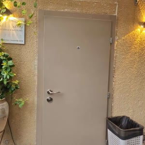 דלת חומה עם ידית כסופה וקיר צהוב