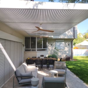 פרגולה אלומיניום בחצר עם ריהוט גן ושולחן אוכל