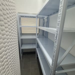 מדפים מתכתיים בחדר קטן עם חלון
