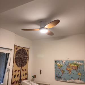 מאוורר תקרה מודרני מותקן בתקרה עם כנפי עץ וגוף תאורה דולק