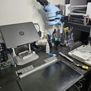 שולחן עבודה עם מיקרוסקופ וכלי תיקון מחשבים