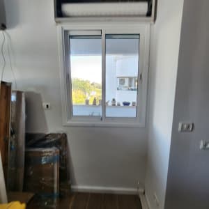 חלון אלומיניום עם מסגרת לבנה וקיר לבן