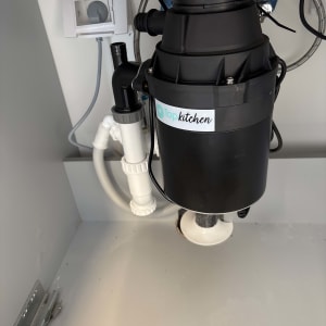 מכשיר טוחן אשפה מתחת לכיור במטבח