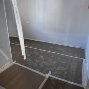 חדר עם רצפה מכוסה בקרטון להגנה במהלך שיפוץ