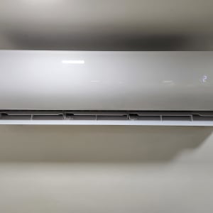 מזגן קיר לבן עם תצוגת טמפרטורה דיגיטלית