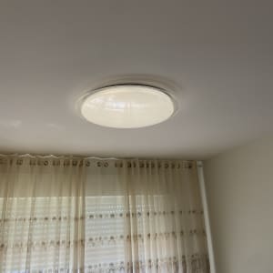 מנורת תקרה עגולה מותקנת על תקרה לבנה