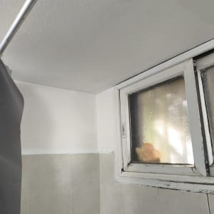 חלון קטן עם מסגרת מתכת, קיר צבוע מחדש