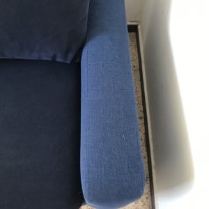 ספה כחולה עם כתמים קטנים על הידית