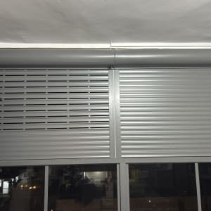 תריסי אלומיניום אפורים מותקנים על חלון