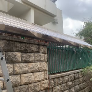 סולם ליד גדר עץ עם גג פלסטיק שקוף