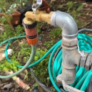 ברז עם ידית אדומה וצינור ירוק מחובר