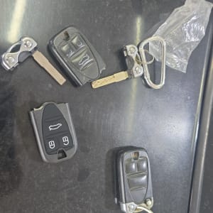 מפתחות ושלטים לרכב מונחים על משטח עבודה לאחר שכפול ותיקון
