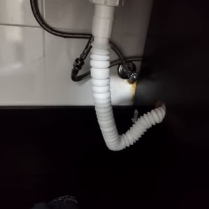 צינור פלסטיק מתחת לכיור עם חיבורים