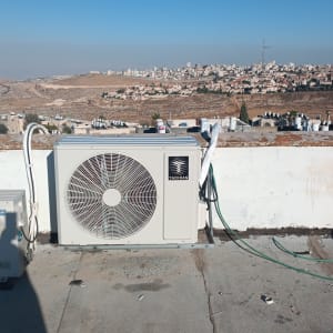 יחידת מיזוג אוויר על גג עם נוף עירוני