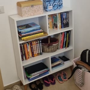 מדף ספרים עם קופסאות, נעליים וסל כביסה