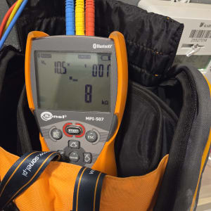 מד מתח חשמלי עם חוטים צבעוניים בתיק עבודה