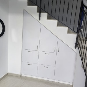 ארון לבן מתחת למדרגות עם ידיות מתכת