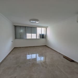 חדר ריק עם קירות לבנים ורצפת שיש