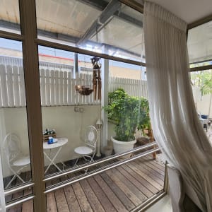 חלון זכוכית גדול עם וילון לבן בצד ימין