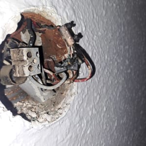 חוטי חשמל חשופים בקיר עם חיבורים ישנים